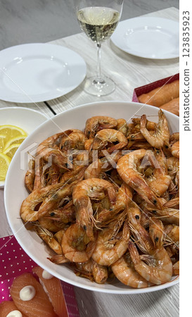 A large white plate of fried shrimp, a glass of wine. A pleasant meeting. Lifestyle. 123835923