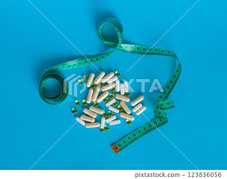 Weight Loss Pills and Measuring Tape, Diet Supplements Capsules, Obesity Lose Tablets, Color Drugs Pile Weight Loss Pills and Measuring Tape, Diet Supplements Capsules, Obesity Lose Tablets, Color Drugs Pile 123836056