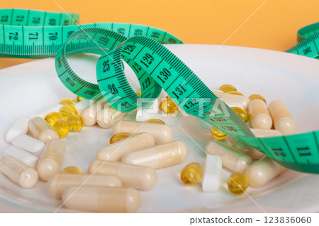 Weight Loss Pills and Measuring Tape, Diet Supplements Capsules, Obesity Lose Tablets, Color Drugs Pile Weight Loss Pills and Measuring Tape, Diet Supplements Capsules, Obesity Lose Tablets, Color Drugs Pile 123836060