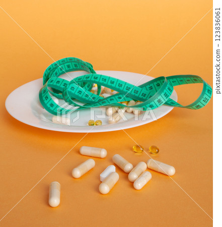 Weight Loss Pills and Measuring Tape, Diet Supplements Capsules, Obesity Lose Tablets, Color Drugs Pile Weight Loss Pills and Measuring Tape, Diet Supplements Capsules, Obesity Lose Tablets, Color Drugs Pile 123836061