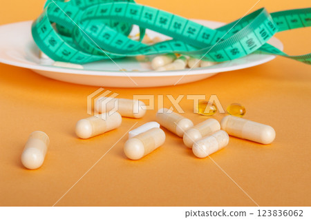 Weight Loss Pills and Measuring Tape, Diet Supplements Capsules, Obesity Lose Tablets, Color Drugs Pile Weight Loss Pills and Measuring Tape, Diet Supplements Capsules, Obesity Lose Tablets, Color Drugs Pile 123836062
