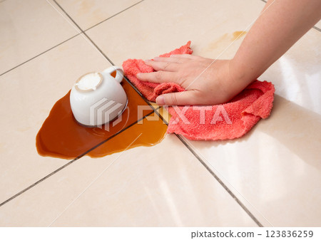 Spilled coffee, coffe puddle stain on tiled floor, messy leak with fallen cup, brown drink spillage Spilled coffee, coffe puddle stain on tiled floor, messy leak with fallen cup, brown drink spillage 123836259