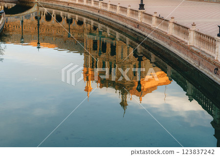 Reflection of historic european building in tranquil canal at sunset. Spain Square, Plaza de Espana Reflection of historic european building in tranquil canal at sunset. Spain Square, Plaza de Espana 123837242