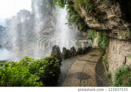 Walkway under the waterfall at Furongzhen in Hunan, China. 123837335