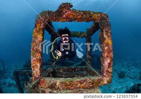 Male diver swimming through the artificial reef concrete block at Racha Yai Island in Phuket 123837354