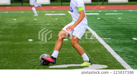 Soccer Player Dribbling the Ball on a Turf Field During an Afternoon Match Soccer Player Dribbling the Ball on a Turf Field During an Afternoon Match 123837386