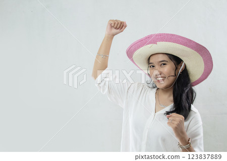 young asian girl wearing straw hat in white dress excited about holidays with waving hands, studio photo isolated on white background young asian girl wearing straw hat in white dress excited about holidays with waving hands, studio photo isolated on white background 123837889