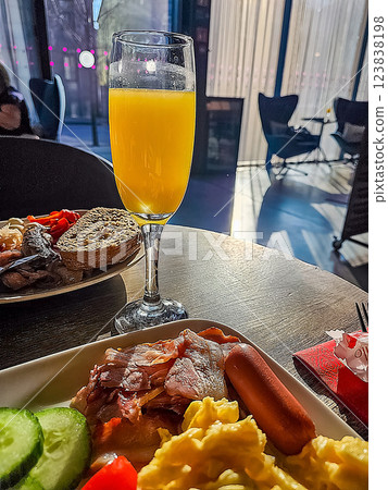 Delicious breakfast with scrambled eggs, bacon, sausage, and orange juice. High quality photo 123838198