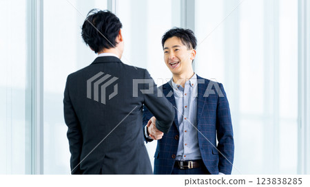two male businessmen shaking hands 123838285