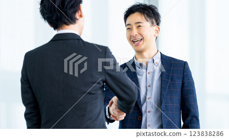two male businessmen shaking hands two male businessmen shaking hands 123838286