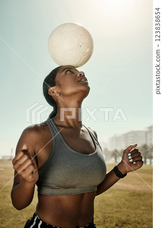 Woman, soccer ball and balance on head in training grass field, sports ground or fitness training club. Football player, black woman and athlete in exercise practice with wellness goals or motivation 123838654