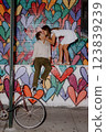 A couple poses by a colorful heart mural in the city, happily enjoying each other 123839239