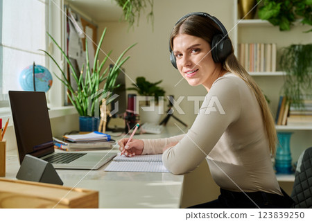 Young woman student studying with laptop notebook, looking at camera, at home Young woman student studying with laptop notebook, looking at camera, at home 123839250
