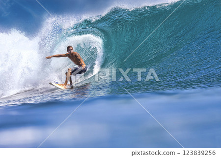 Male surfer on a blue wave 123839256