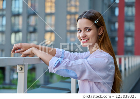 Portrait smiling young teenage red-haired girl looking at camera outdoor, urban style 123839325