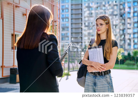 Teenage girl student talking to female teacher, outdoor 123839357
