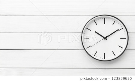 Elegant wall clock displaying time on a white wooden background 123839650