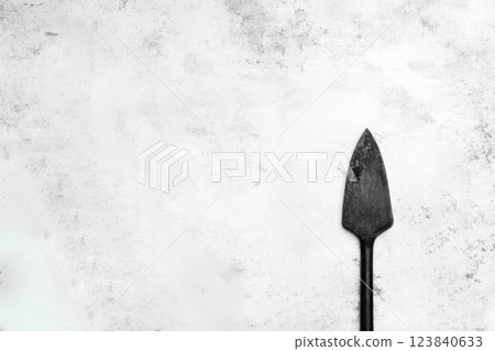 Simple black garden spade on a textured background 123840633