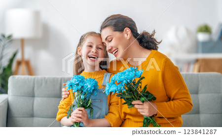 daughter is congratulating mom and giving her flowers daughter is congratulating mom and giving her flowers 123841287