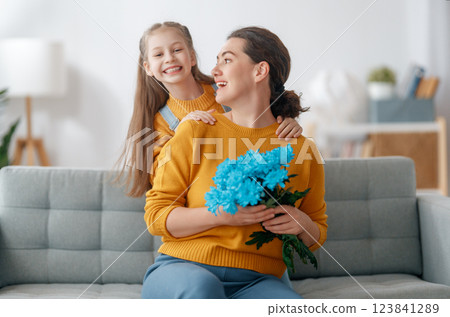 daughter is congratulating mom and giving her flowers daughter is congratulating mom and giving her flowers 123841289