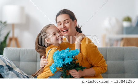 daughter is congratulating mom and giving her flowers daughter is congratulating mom and giving her flowers 123841290