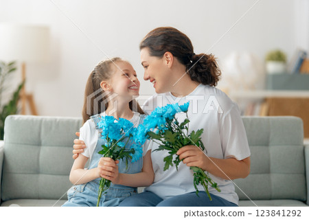 daughter is congratulating mom and giving her flowers daughter is congratulating mom and giving her flowers 123841292
