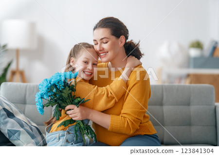 daughter is congratulating mom and giving her flowers 123841304