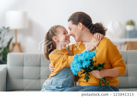 daughter is congratulating mom and giving her flowers daughter is congratulating mom and giving her flowers 123841313