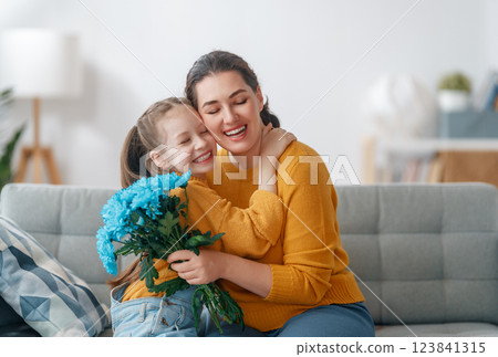 daughter is congratulating mom and giving her flowers 123841315