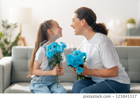 daughter is congratulating mom and giving her flowers 123841317