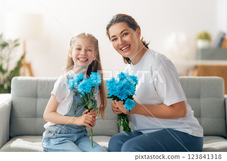 daughter is congratulating mom and giving her flowers daughter is congratulating mom and giving her flowers 123841318