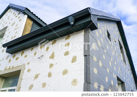 Thermal insulation of the facade of a residential building with thermal insulation material plates Thermal insulation of the facade of a residential building with thermal insulation material plates 123842755