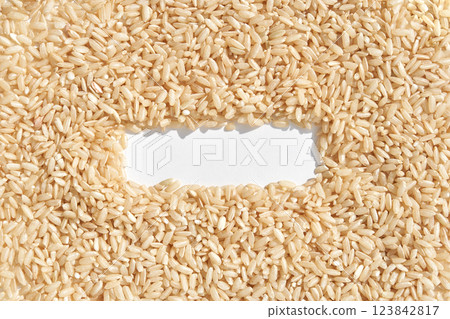 Brown rice grains forming a rectangular border on white background 123842817