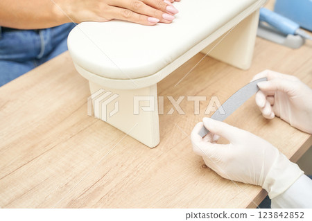 Caucasian female manicure session with close up of hand and nail technician 123842852