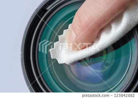 Close up of a hand cleaning camera lens with cloth ensuring pristine clarity Close up of a hand cleaning camera lens with cloth ensuring pristine clarity 123842882