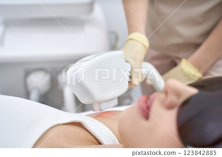 Asian female receiving laser hair removal treatment at beauty clinic 123842885