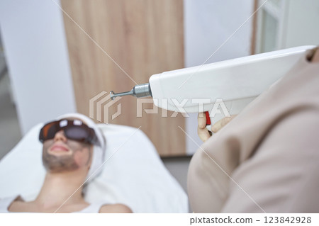 Young caucasian female receiving cosmetic laser skin treatment at spa clinic Young caucasian female receiving cosmetic laser skin treatment at spa clinic 123842928