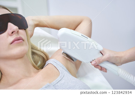 Caucasian female receiving laser hair removal treatment on underarm Caucasian female receiving laser hair removal treatment on underarm 123842934