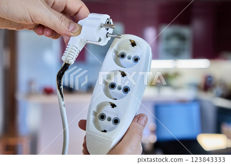 An electrical extension cord with tee became charred and caused short circuit due to overload. An electrical extension cord with tee became charred and caused short circuit due to overload. 123843333