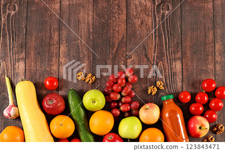 Grapes, oranges, tomatoes, apples, bananas, nuts and natural juice on a wooden background, detox diet and weight loss concept, healthy vegan products for a healthy lifestyle, advertising for a store. Grapes, oranges, tomatoes, apples, bananas, nuts and natural juice on a wooden background, detox diet and weight loss concept, healthy vegan products for a healthy lifestyle, advertising for a store. 123843471