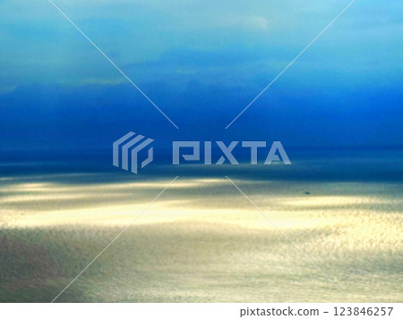 金色的海面和蔚藍的天空營造出一種平靜的氛圍。 123846257