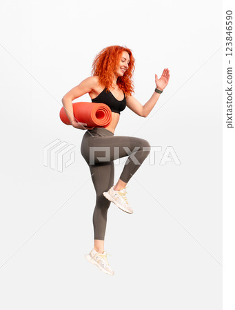 Female jogger woman holding rolled up mat in Female jogger woman holding rolled up mat in 123846590