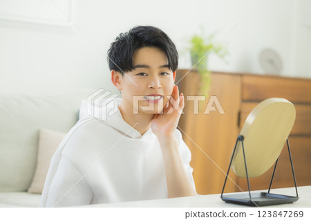 A young man looking at a mirror A young man looking at a mirror 123847269