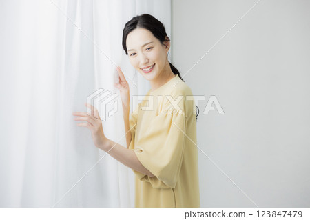 Woman opening curtain Woman opening curtain 123847479