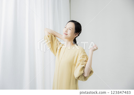 Woman opening curtain 123847483