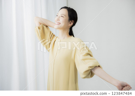 Woman opening curtain 123847484