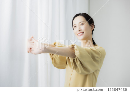 Woman opening curtain 123847486