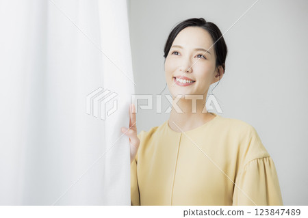 Woman opening curtain 123847489