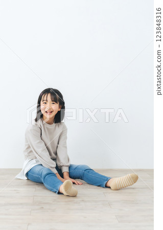 一個女孩坐在地板上的肖像 一個女孩坐在地板上的肖像 123848316