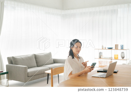 一位 30 多歲的女性在家工作 123848739